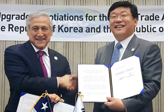 한-칠레 자유무역협정 개선협상   주형환 산업통상자원부 장관(오른쪽)과 에랄도 무뇨스(Heraldo Munoz) 칠레 외교부 장관이 18일(현지시간) 페루 리마에서 한-칠레 자유무역협정(FTA) 개선협상서에 서명한 뒤 교환하고 있다.       주형환 장관은 17~18일 페루 리마에서 개최된 제28차 아시아태평양경제협력체(APEC) 각료회의 참석했다.